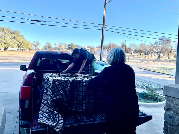 Photos of Bridgit and Sandy covering the armoire in the truck.