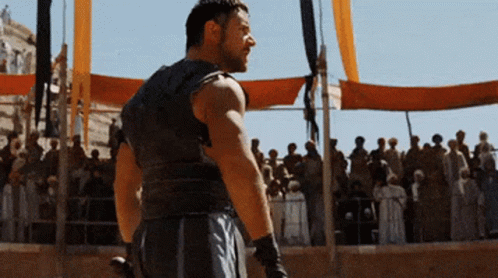 a man is standing in front of a crowd with a sword a man is standing in front of a crowd with a sword