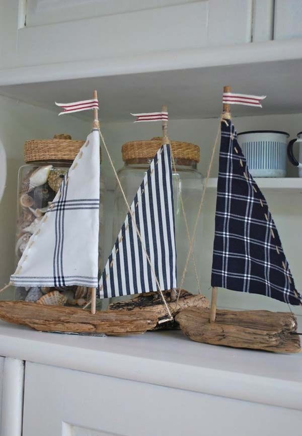 This may contain: a sailboat in a glass bottle on top of a white shelf next to other items