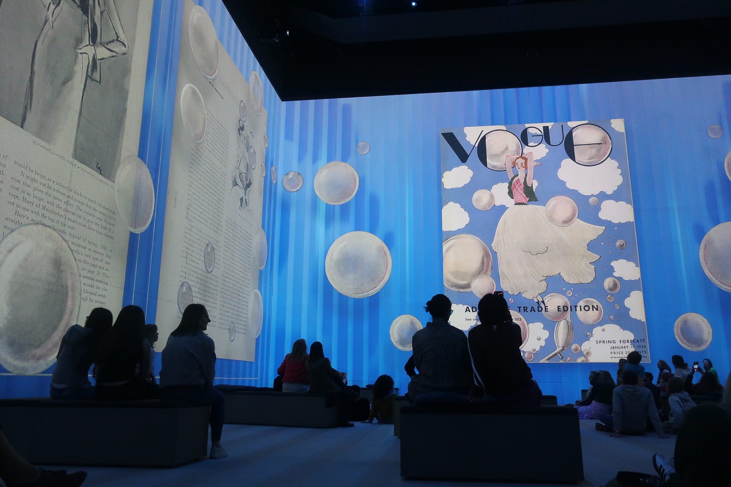 A Vogue fashion magazine cover page projected onto a digital screen