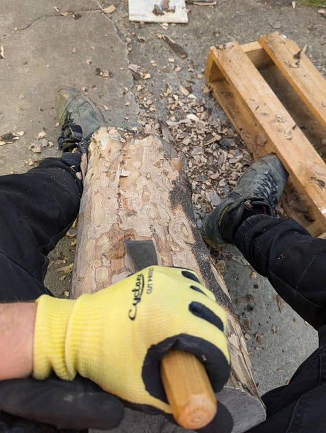 Michal Plis starting to carve a wood sculpture outdoors