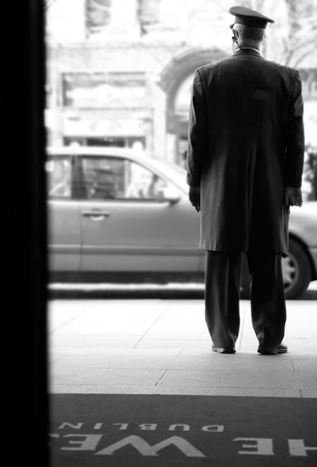 This may contain: a black and white photo of a man standing in front of a sign that says the metropolitan This may contain: a black and white photo of a man standing in front of a sign that says the metropolitan