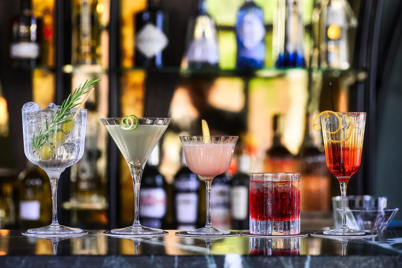 Several mutli-colored cocktails sitting on a bar Several mutli-colored cocktails sitting on a bar