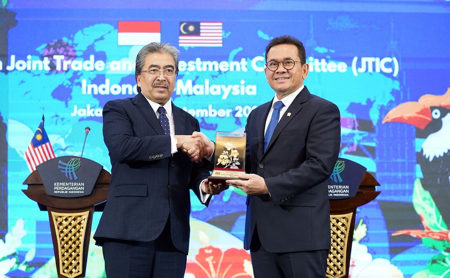 Malaysian Investment, Trade and Industry Minister Johari Abdul Ghani receives a memento from Indonesian Trade Minister Budi Santoso Malaysian Investment, Trade and Industry Minister Johari Abdul Ghani receives a memento from Indonesian Trade Minister Budi Santoso