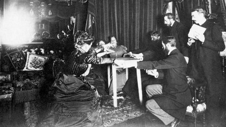 Eusapia Palladino demonstrates her ability to levitate a table during a séance in 1898 at the home of astronomer Camille Flammarion.