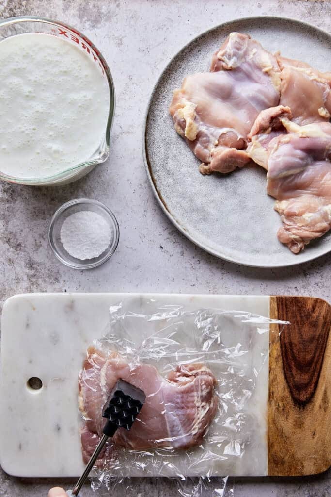 Chicken thigh being flattened for even cooking, an important step in the best fried chicken sandwich recipe.
Chicken thigh being flattened for even cooking, an important step in the best fried chicken sandwich recipe.