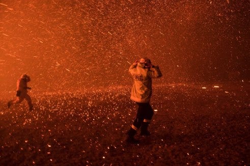Firefighters run for safety from embers during the Black Summer fires in December 2019. Firefighters run for safety from embers during the Black Summer fires in December 2019.