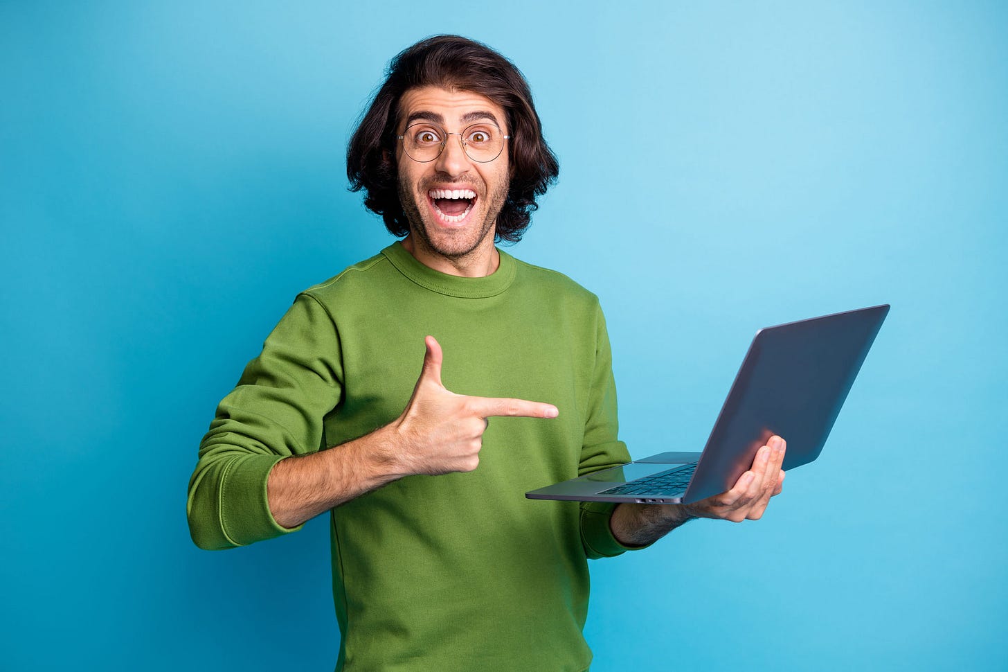 Happy and surprised man holding a laptop.