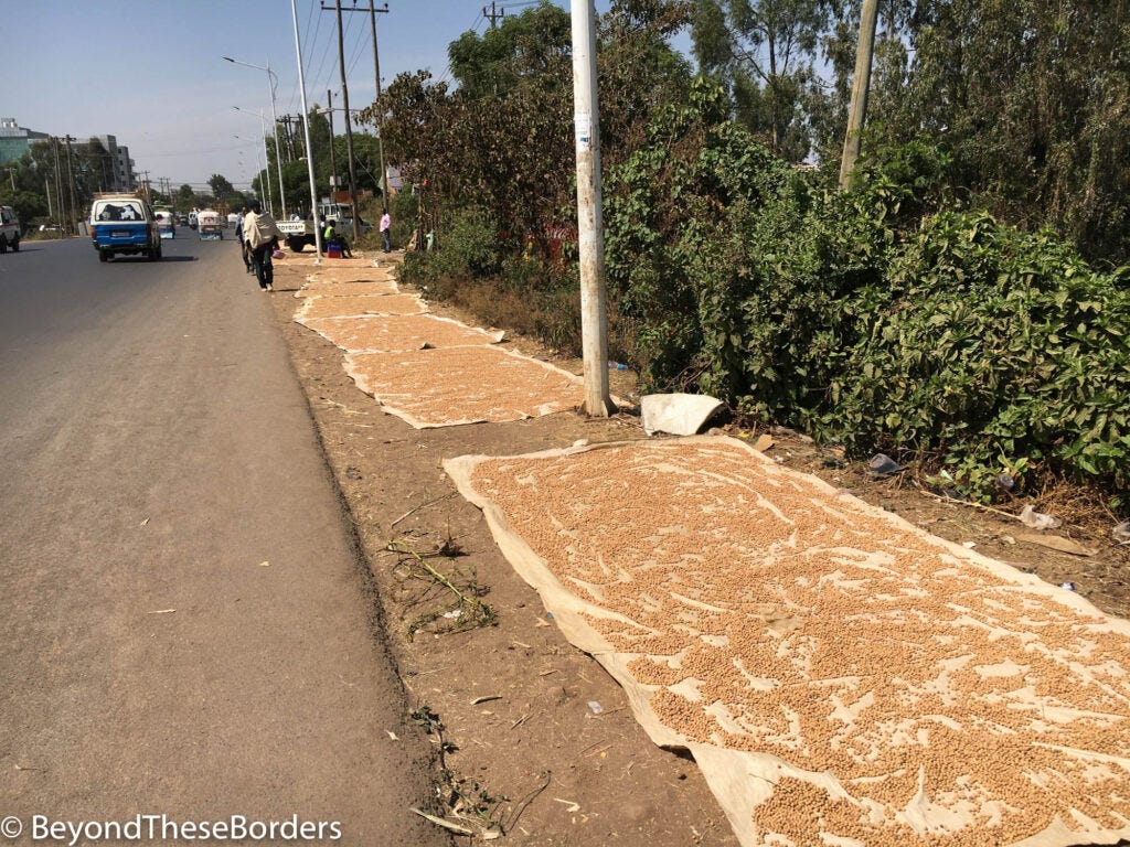 Crops drying in the sun next to the street.