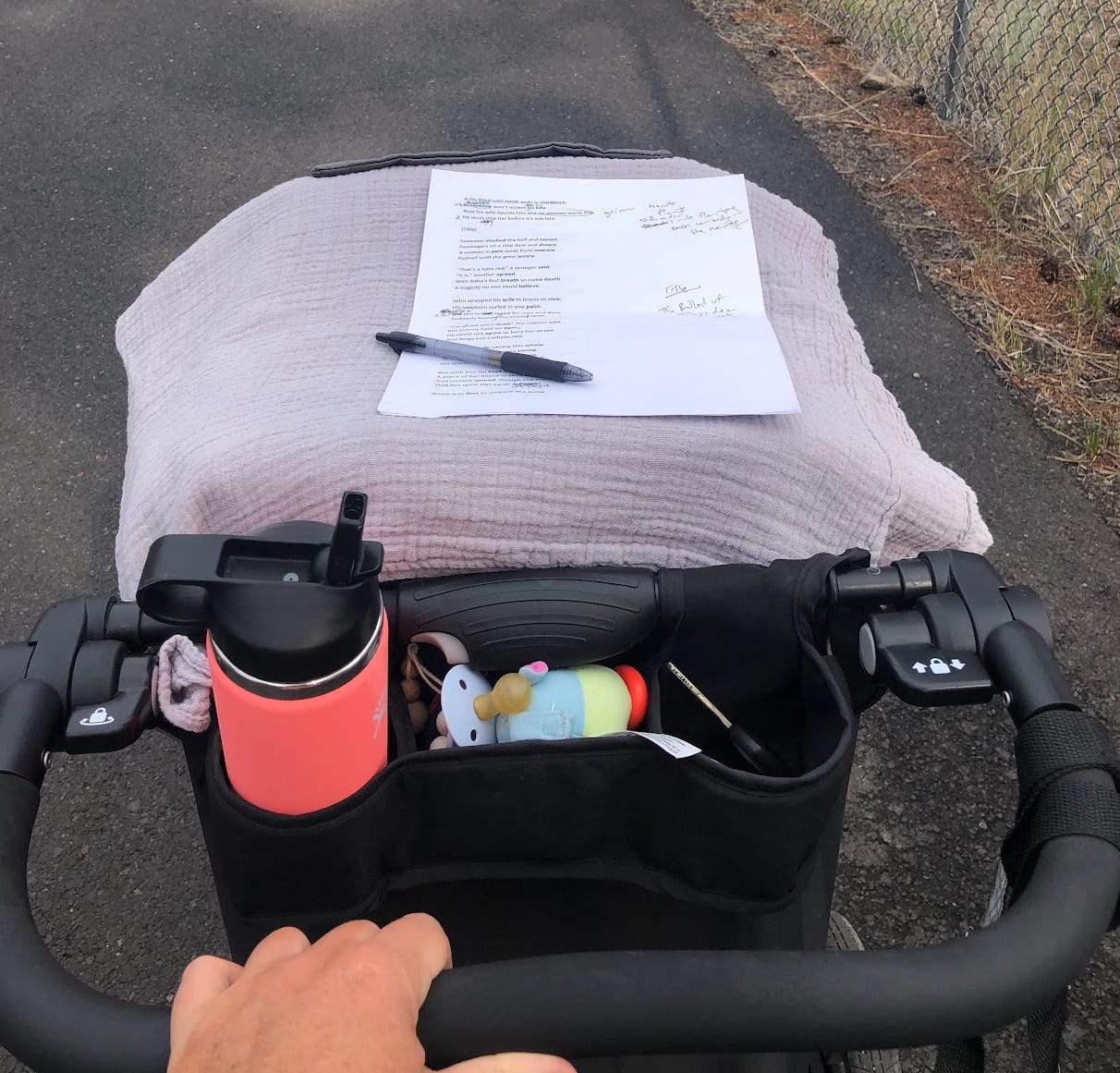 pen and paper atop stroller on sidewalk