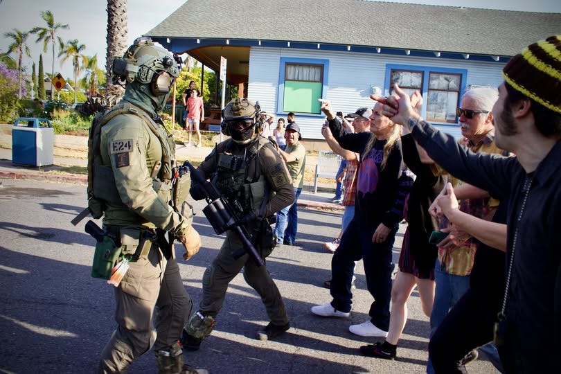 civilians are chanting "shame, shame" at ICE agents in full military regalia civilians are chanting "shame, shame" at ICE agents in full military regalia