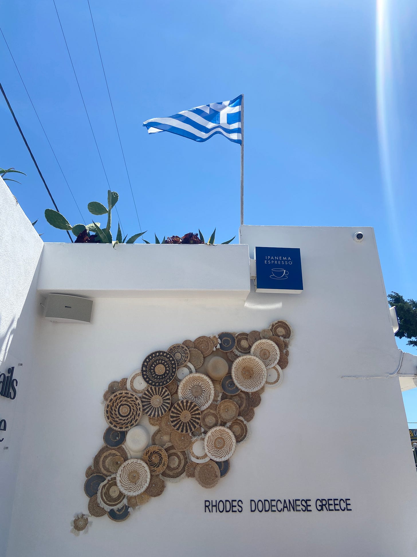 Greek coffee shop with flag in sun