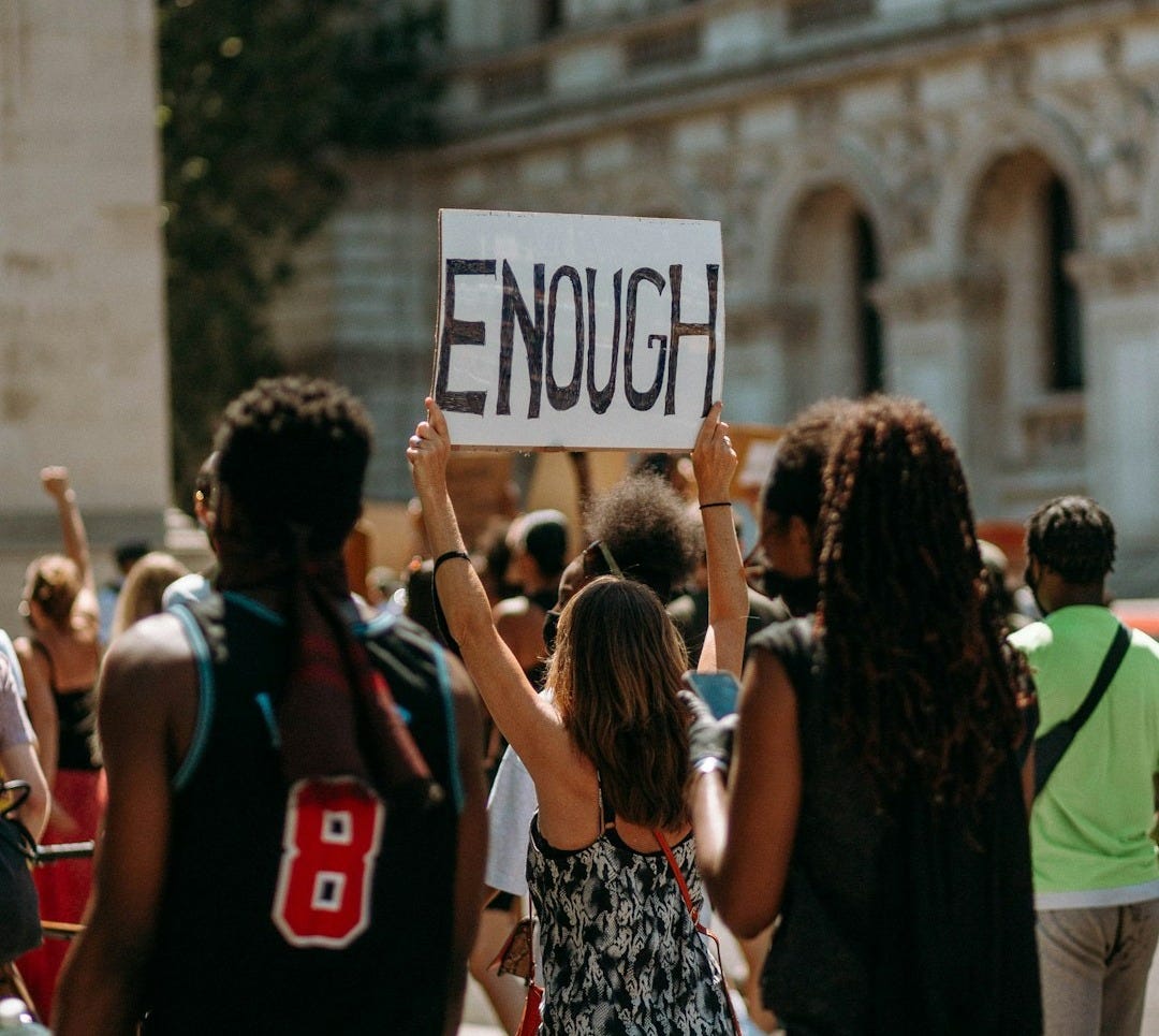 people holding a signage during daytime people holding a signage during daytime