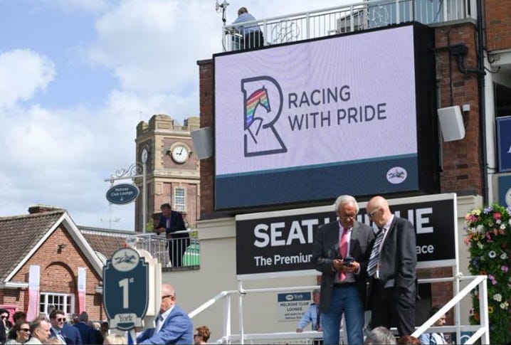 Racing With Pride emblem on a big screen at York Racecourse