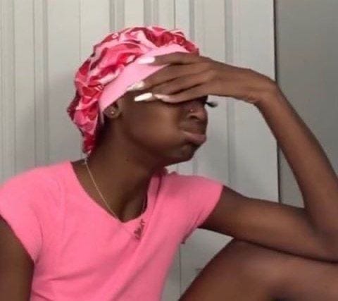 This may contain: a woman sitting on the ground wearing a pink shirt and a flowered headband