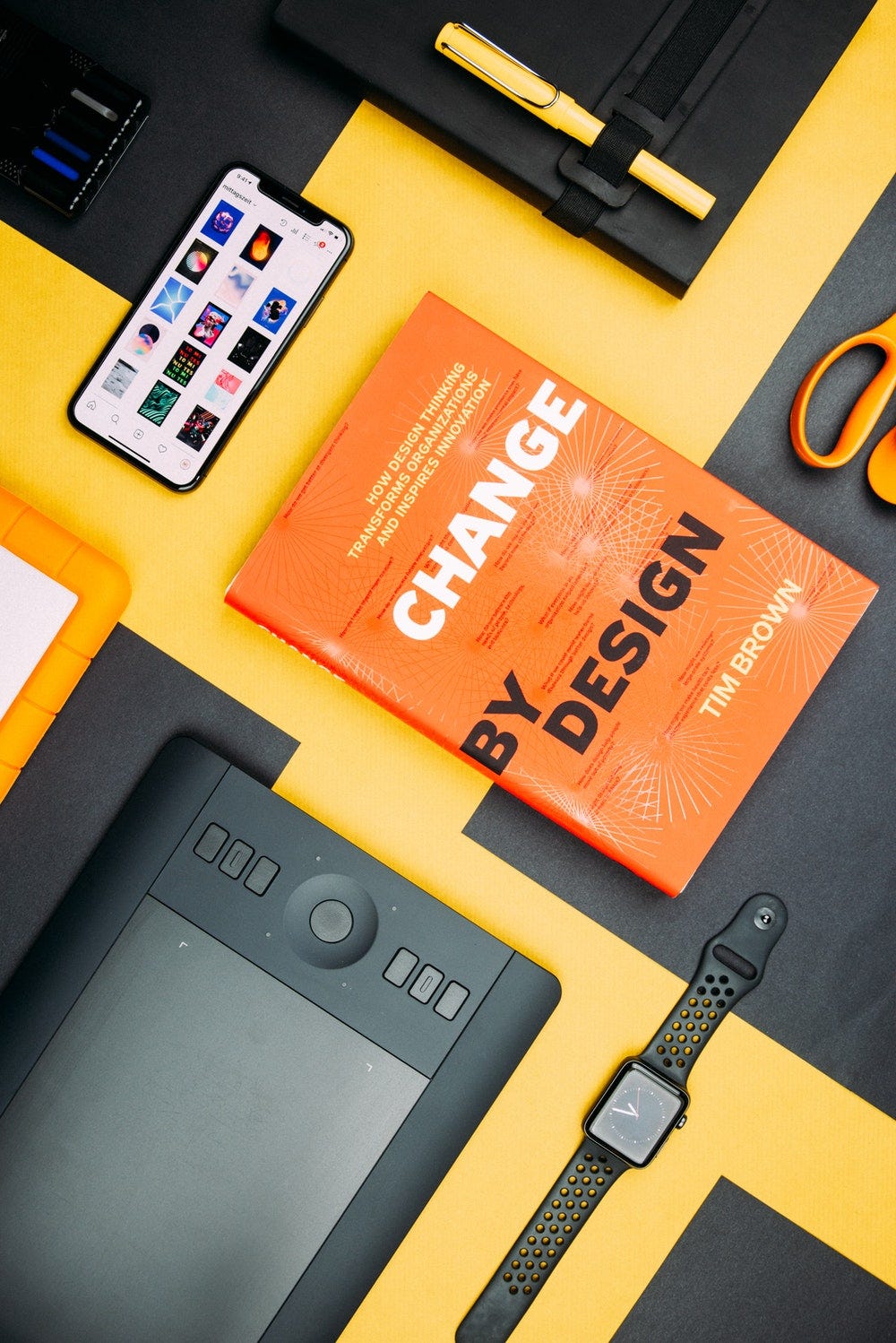 Change by Design by Tim Brown book beside smartphone Change by Design by Tim Brown book beside smartphone