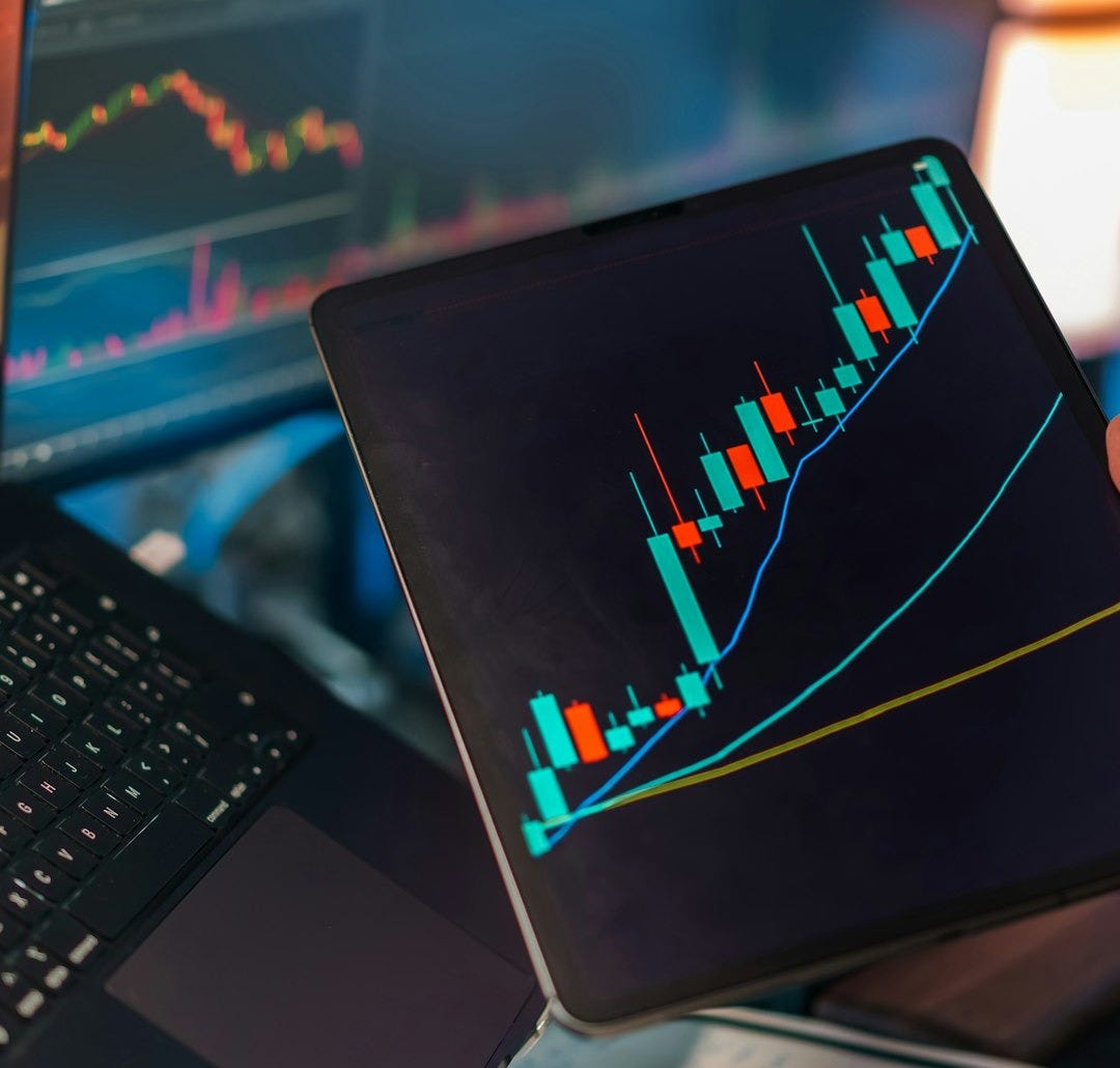Trading charts displayed on multiple screens and tablet Trading charts displayed on multiple screens and tablet