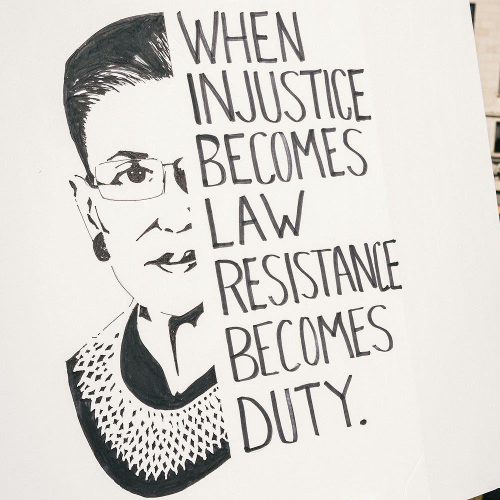 a person holding a sign that says when justice becomes law, resistance becomes duty