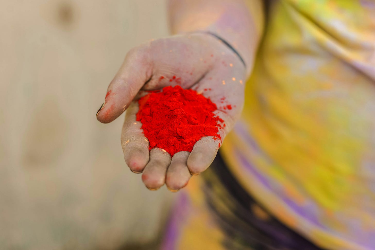A hand holding red powder