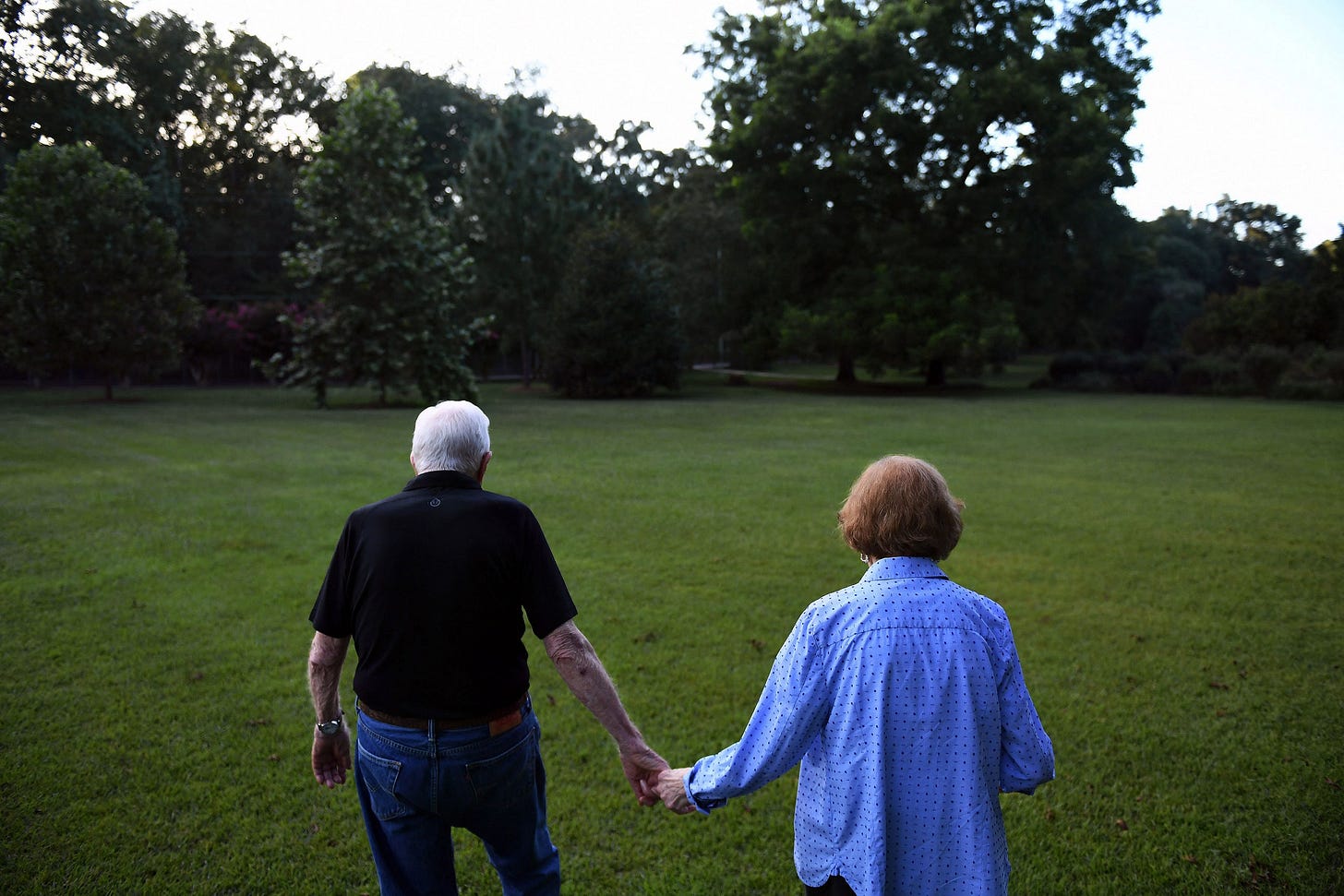 President Jimmy Carter and his wife Rosalynn walking through grass holding hands President Jimmy Carter and his wife Rosalynn walking through grass holding hands