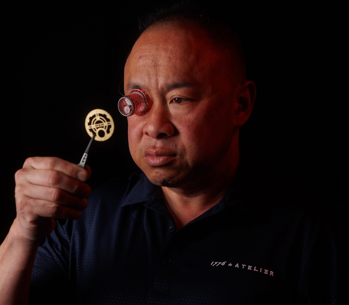 Image of Jason wearing a loupe and holding a plate with tweezers Image of Jason wearing a loupe and holding a plate with tweezers