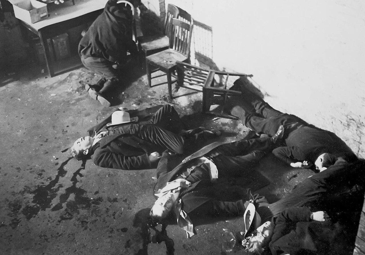 Six men lie dead on the floor with blood splattered around them Six men lie dead on the floor with blood splattered around them