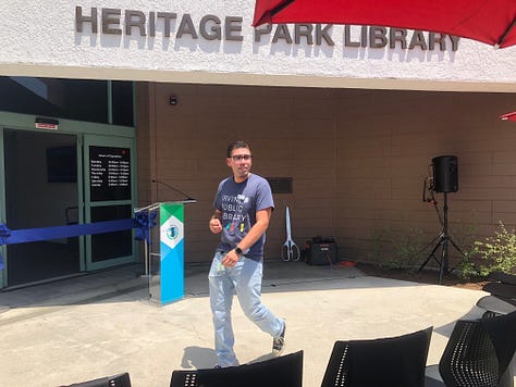 Ribbon Cutting, Chris Slama, and a mom and chld inside the library