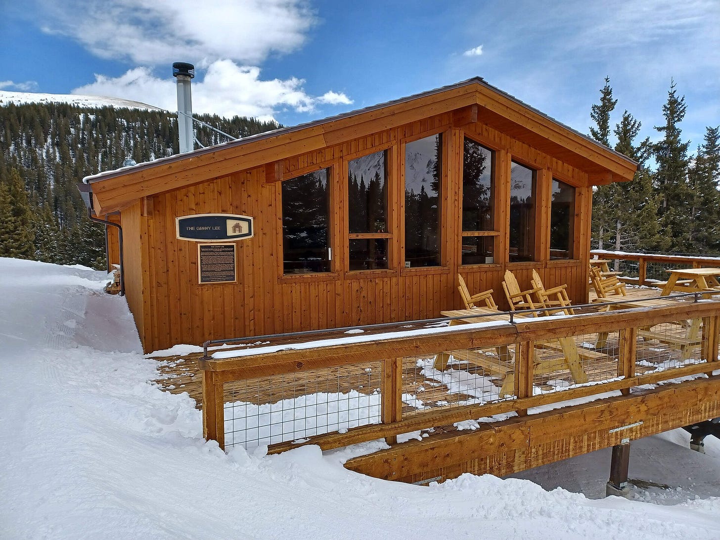 Wooden Ginny Lee lodge with deck chairs beside a snowy run at Loveland Wooden Ginny Lee lodge with deck chairs beside a snowy run at Loveland