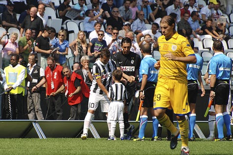 Juventus vs Parma, September 11, 2011: team huddle, player introductions, Antonio Conte coaching from the sideline, Pirlo and Del Piero in action, and Juventus players celebrating a goal during the opening match at Juventus Stadium.