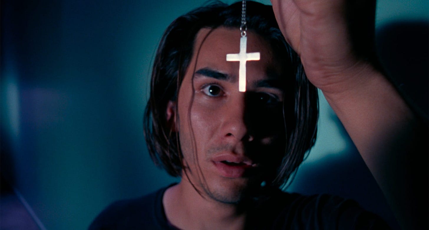 Nowhere | Still features James Duval as Dark holding a crucifix in front of his face.
