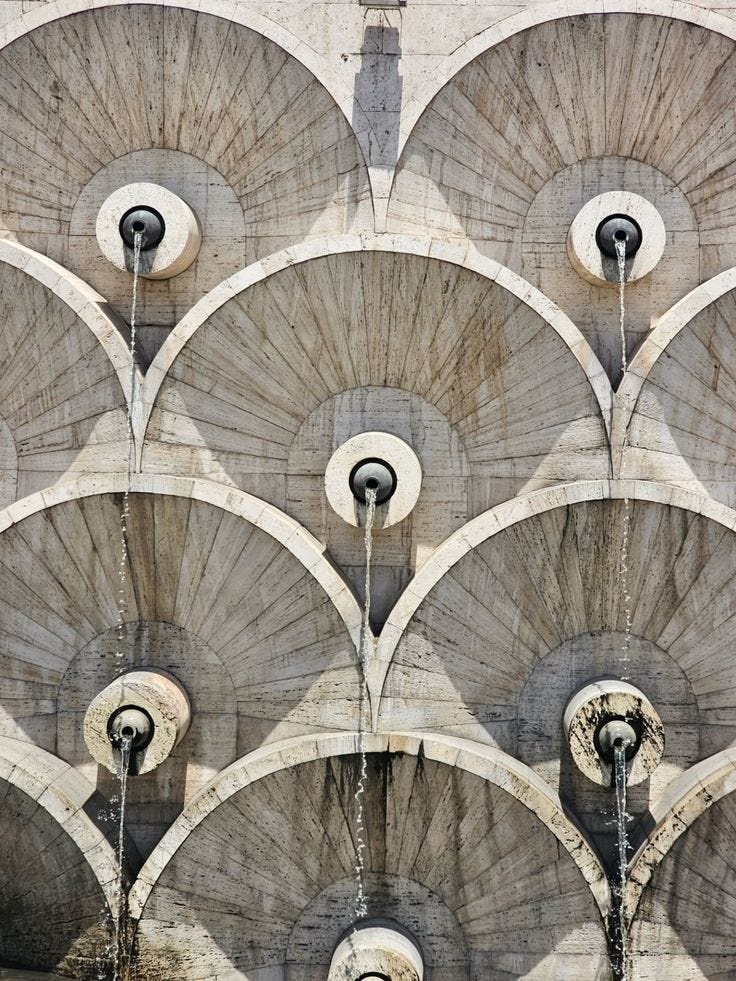 This may contain: the water is running down the side of the building's wall and it looks like art