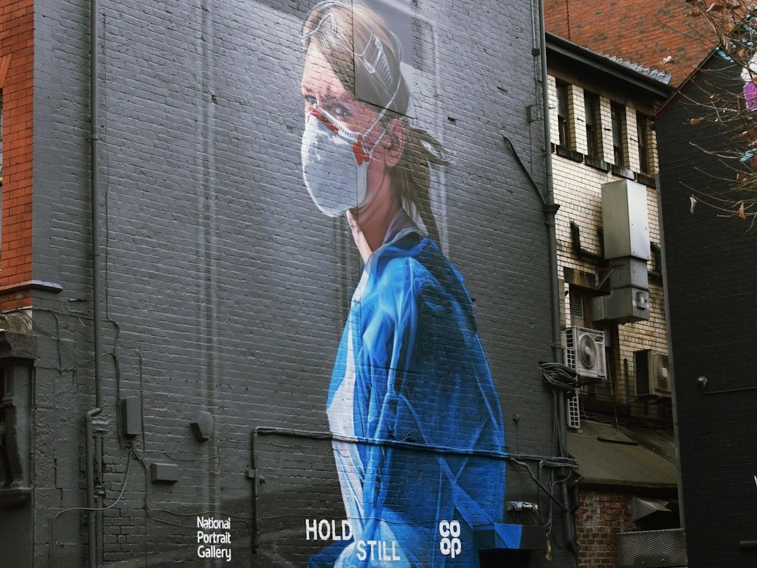 woman in blue dress standing near building during daytime woman in blue dress standing near building during daytime