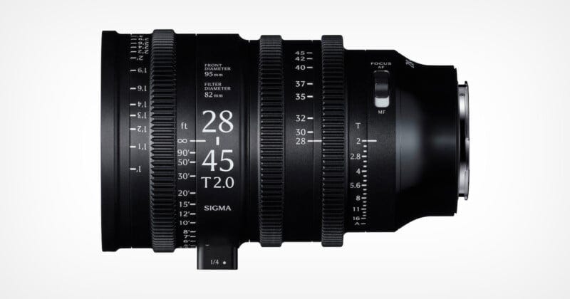 A black Sigma 28-45mm T2.0 cine lens with white engraved markings for focus, zoom, and aperture, shown against a plain white background, viewed from the side.