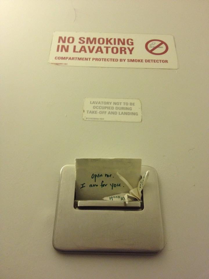 a handwritten note stuck in an airplane bathroom ashtray.