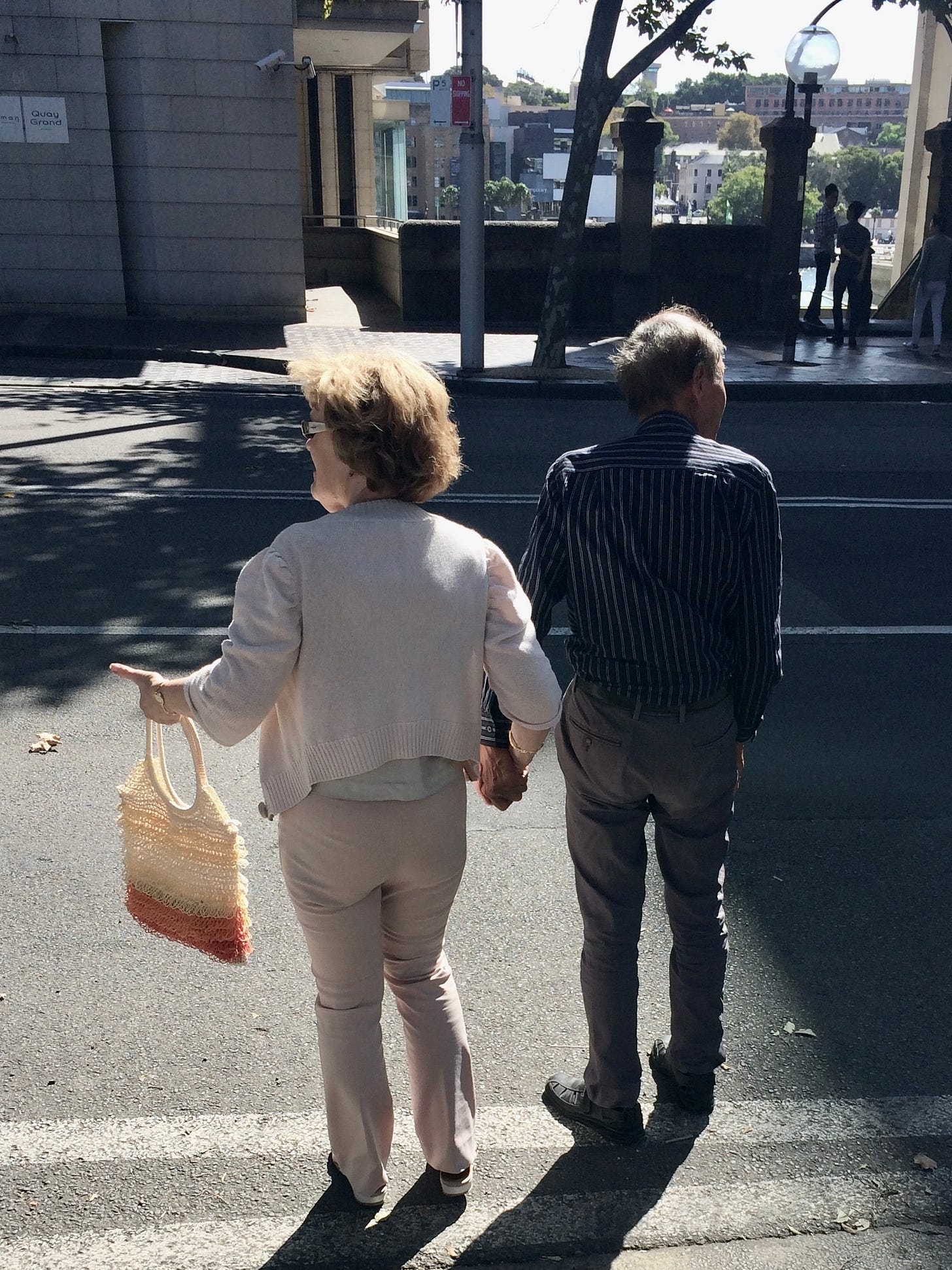 couple holding hands crossing the road