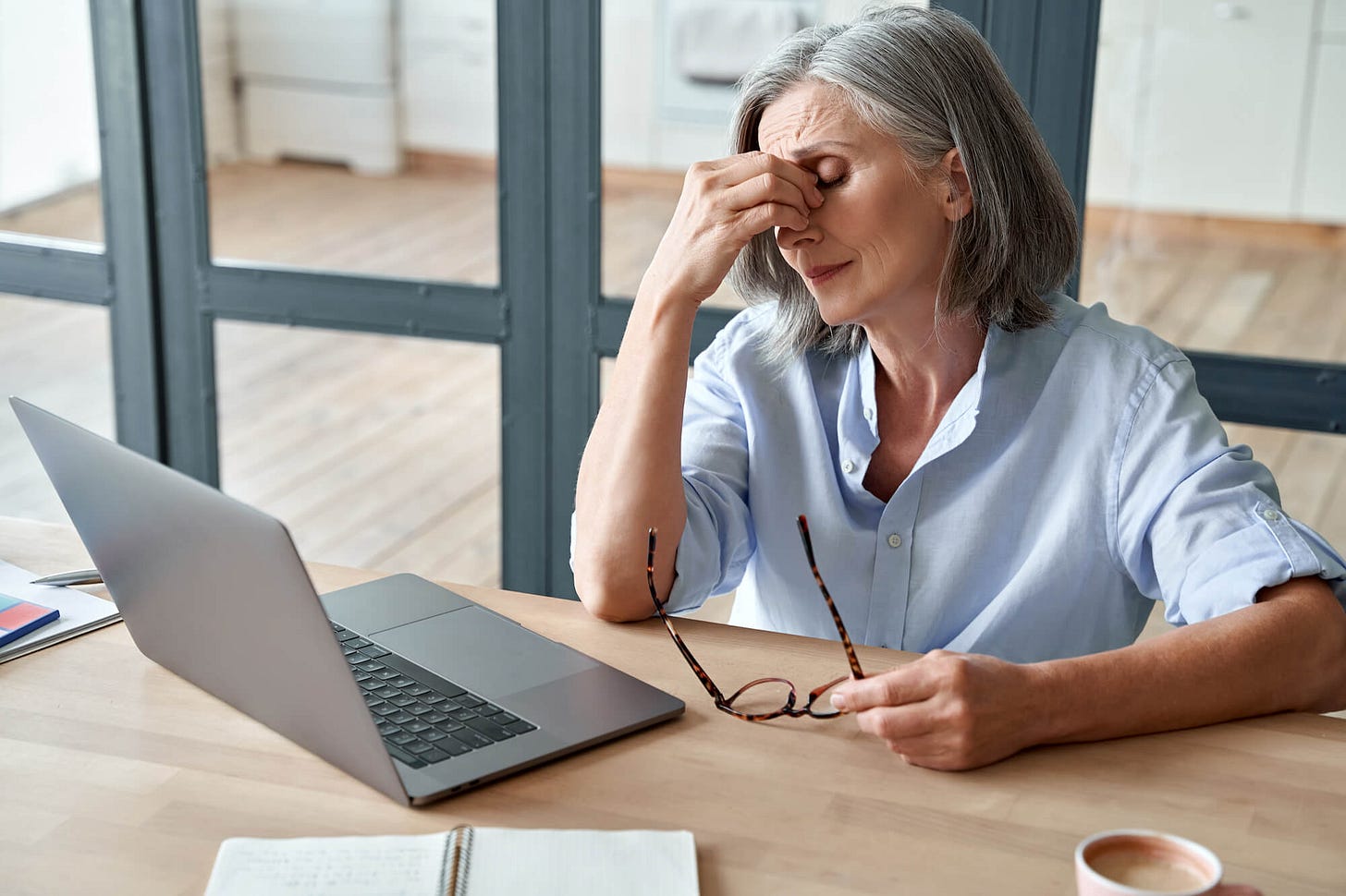 A worried older lady in front of laptop