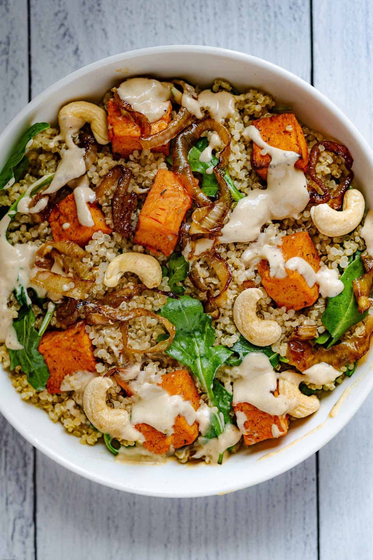 Sweet Potato & Quinoa Salad with Tahini in a white bowl.