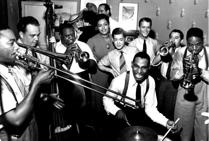 This may contain: a group of men playing musical instruments in a room