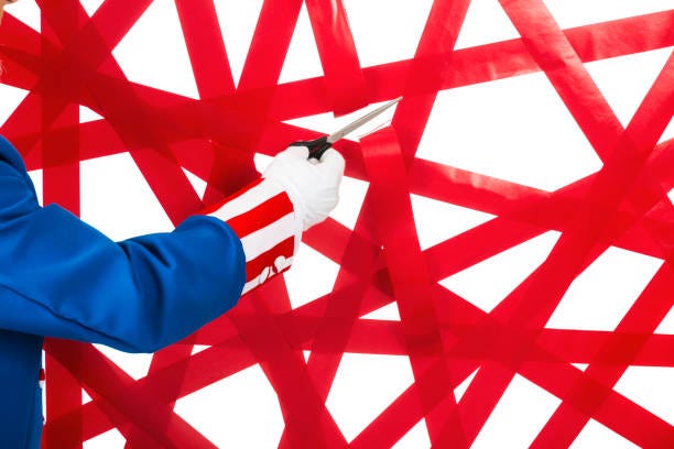 Uncle Sam cutting through a wall of red tape against a white background A patriotic Uncle Sam cutting through a wall of red tape with a pair of scissors in his white gloved hand. He is wearing a red, white and blue coat and top hat that has a blue ban and white star while standing in from of a white background. government red tape stock pictures, royalty-free photos & images