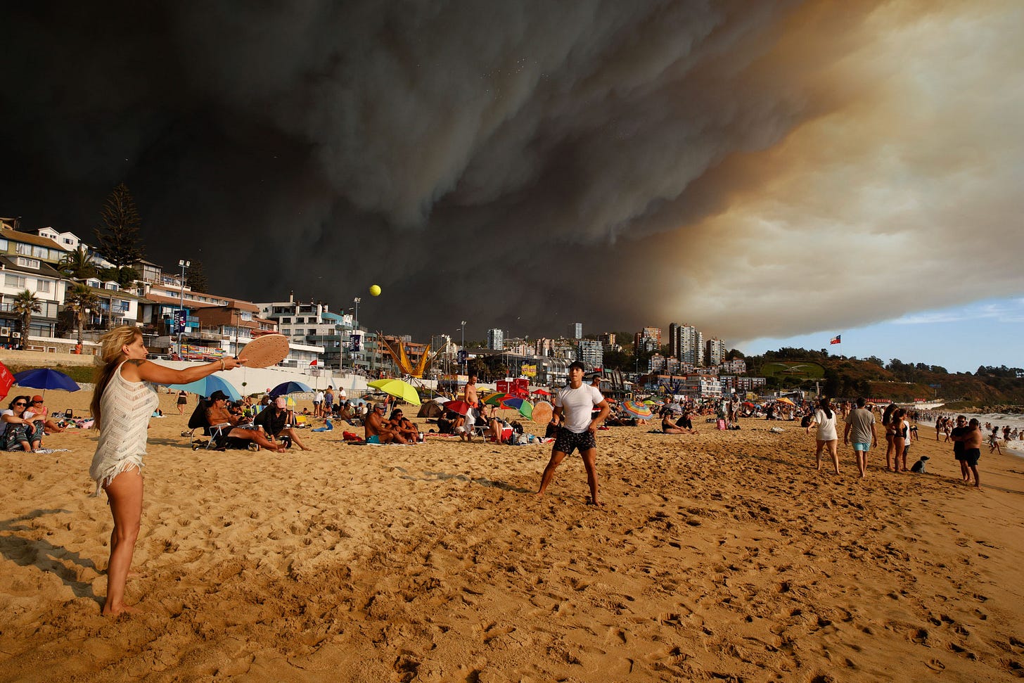 APTOPIX Chile Fires Vacationers play paddle ball as nearby forest fires burn in Viña del Mar, Chile, Feb. 2.Martin Thomas—Aton Chile/AP.