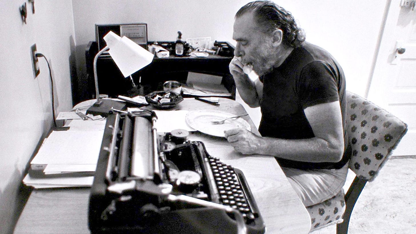 Charles Bukowski em sua mesa de trabalho. Créditos: https://bukowski.net/photos/ Charles Bukowski em sua mesa de trabalho. Créditos: https://bukowski.net/photos/
