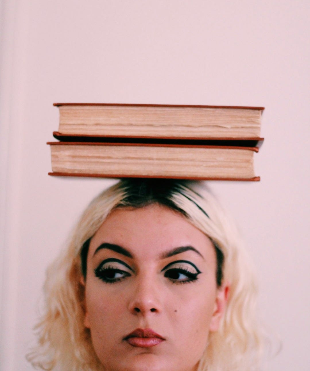 two books on top of woman's head