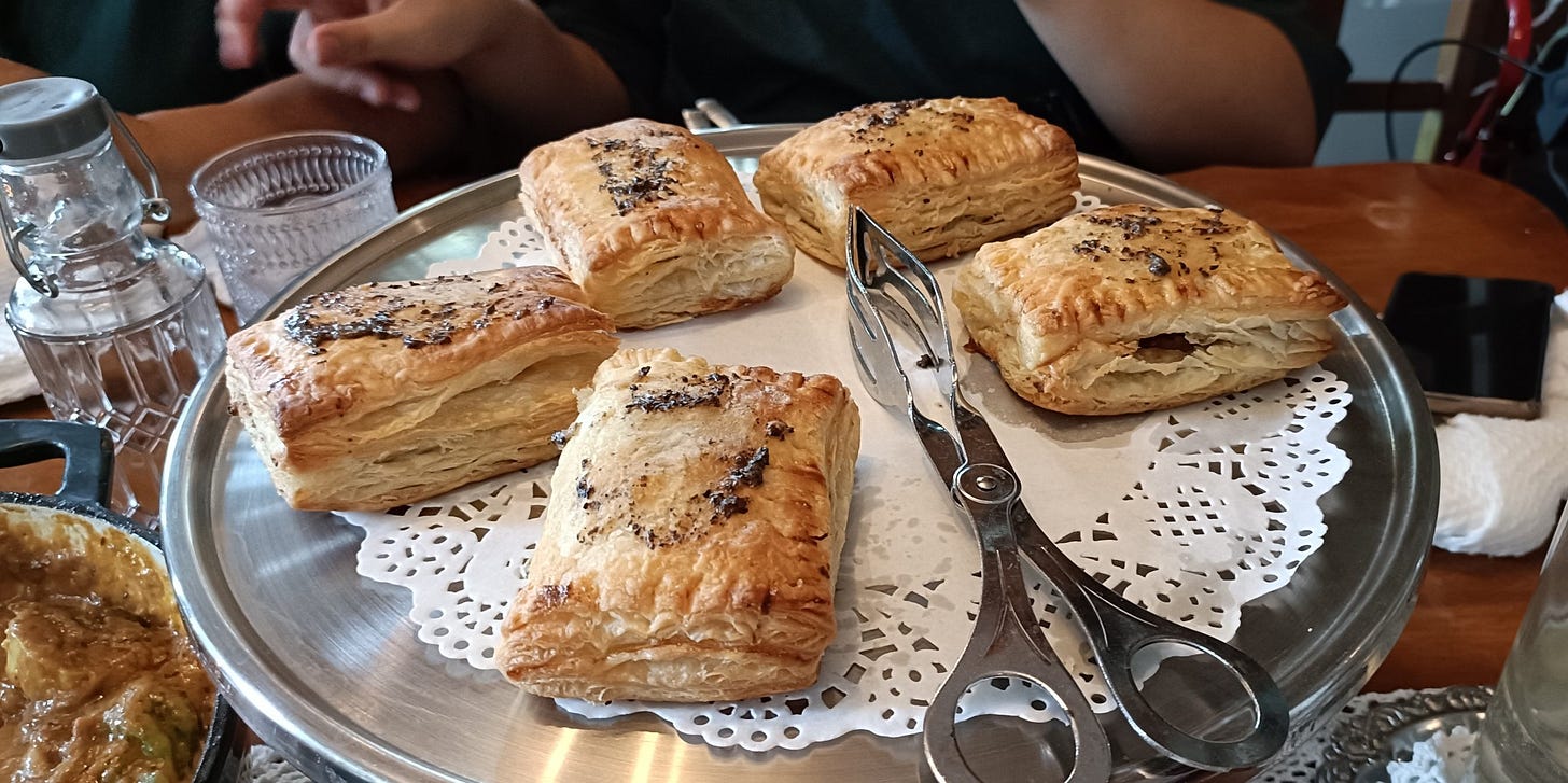 A platter of empanadas with tongs