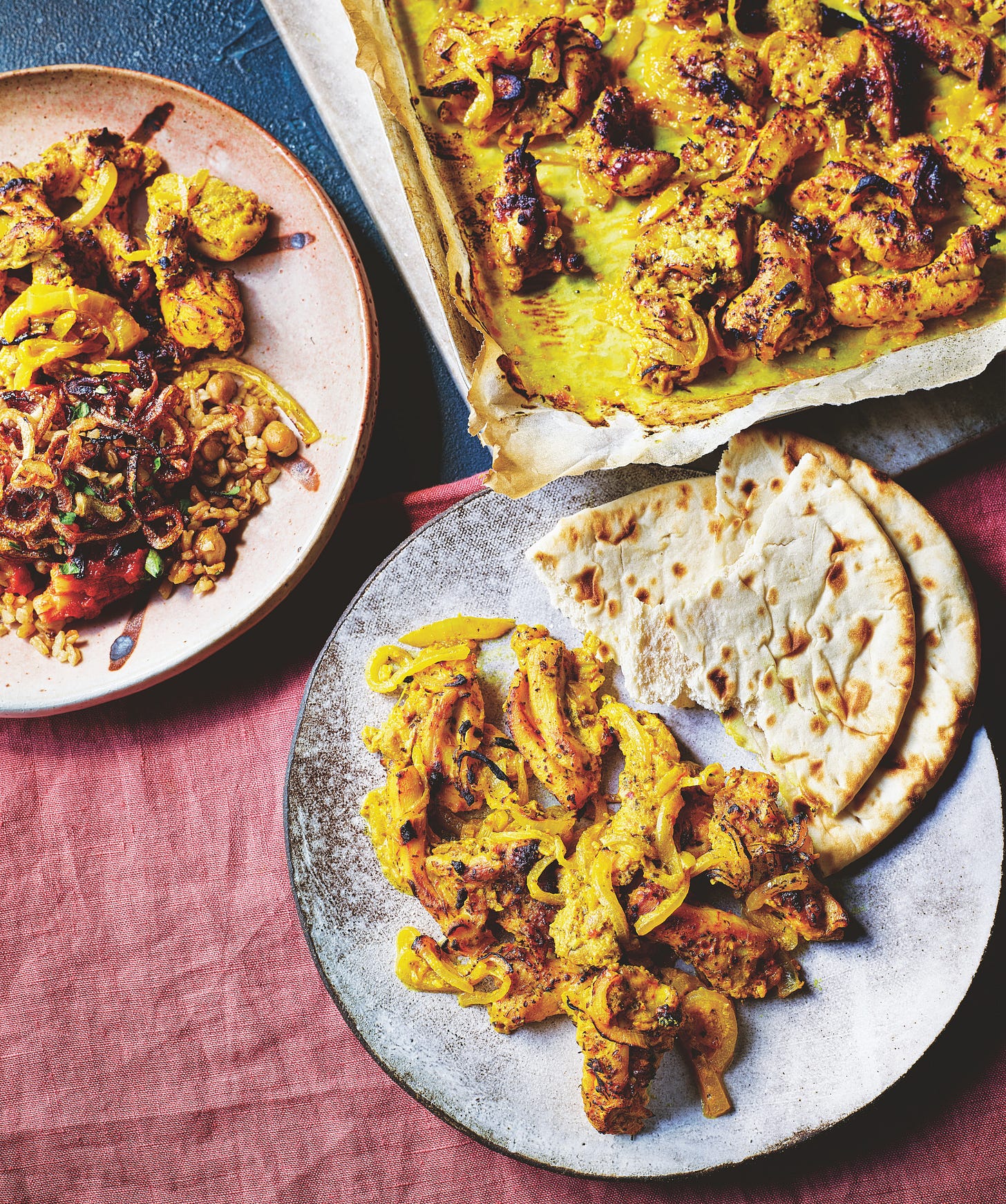 Baking sheet of saffront chicken and plate of chicken with flatbreads.
