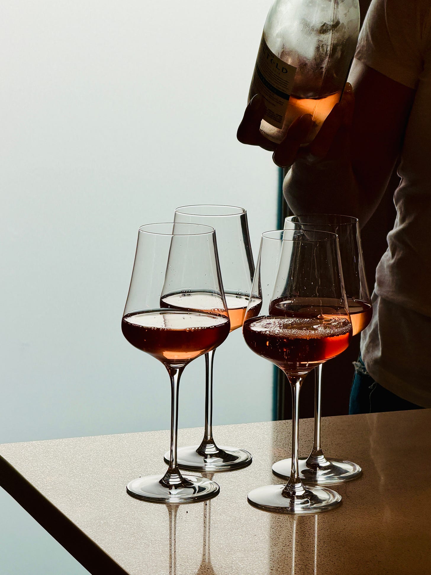 Four poured glasses of rose wine Four poured glasses of rose wine