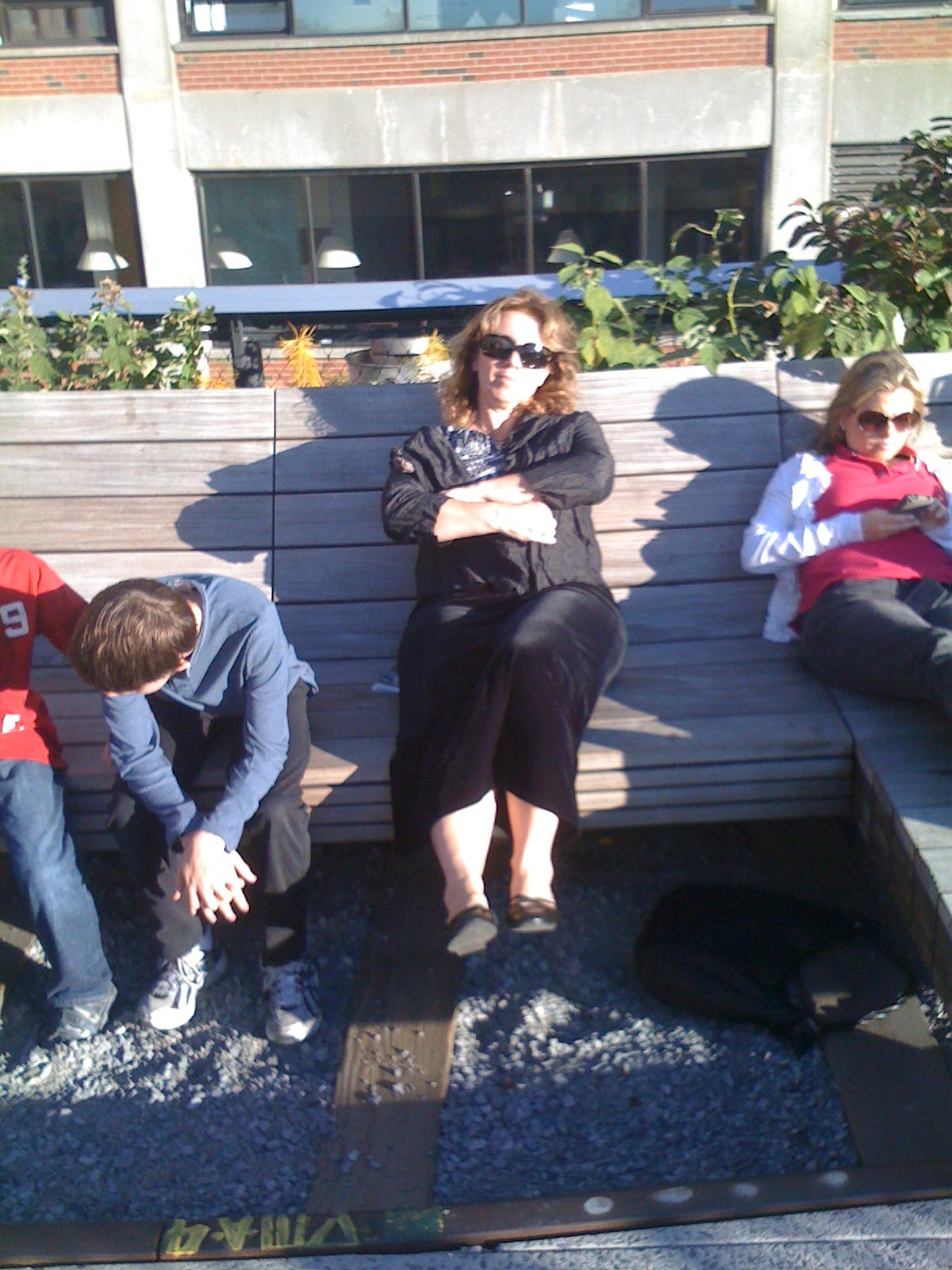 A jet-lagged women relaxes on a bench in the sun at High Line park New York.
