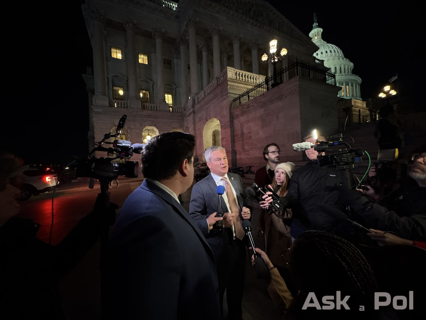 A male politician is lit up by TV crews' lights on a dark night outside the US Capitol. Photo Matt Laslo for © www.askapol.com 