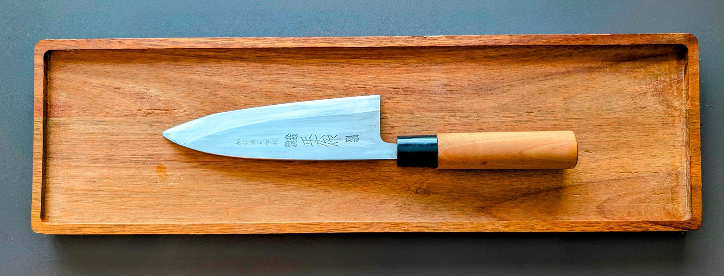 Close-up of a Japanese deba knife, used for heavier prep work in sushi kitchens.