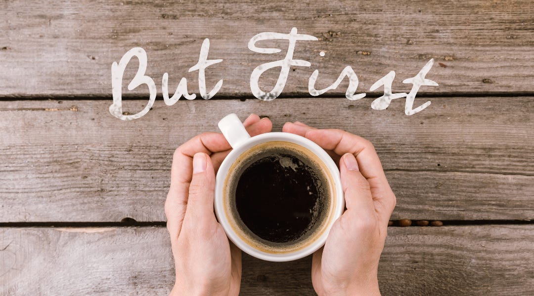 Image shows hands cupping a mug of coffee which is on a bare wood table. Above the cup are the words "But first". Image is intended as an invitation in to do the first thing first - introduce yourself, get to know each other.