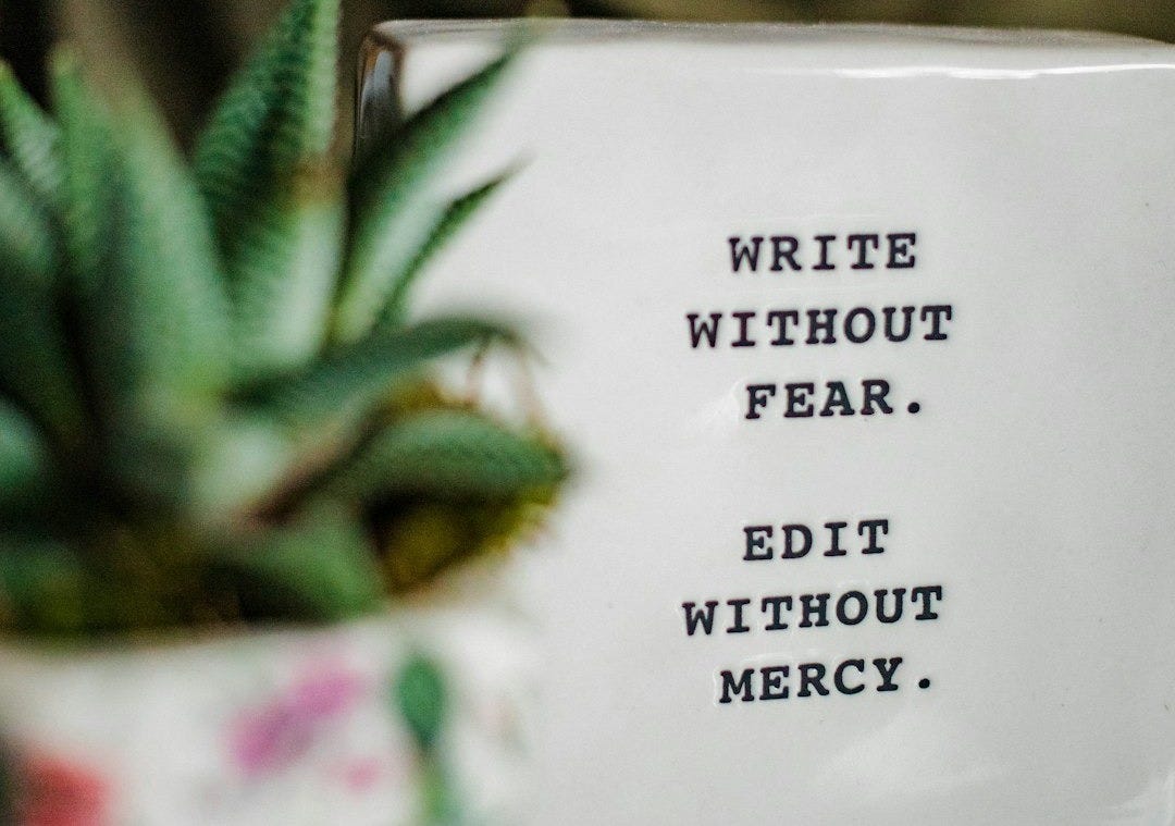 a white box with writing on it next to a plant